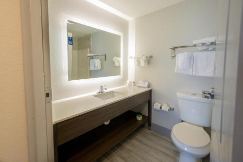 a bathroom with a sink and a toilet and a mirror at Hawthorn Extended Stay by Wyndham Panama City Beach in Panama City Beach