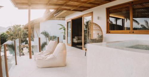 a living room with white furniture on a balcony at Neano Escape in Candidasa