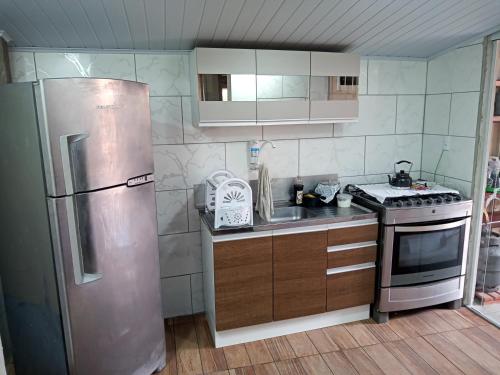 a kitchen with a stainless steel refrigerator and a sink at Casa de Praia Armacao de Itapocoroi 261 - Próximo ao Parque Beto Carrero World in Penha