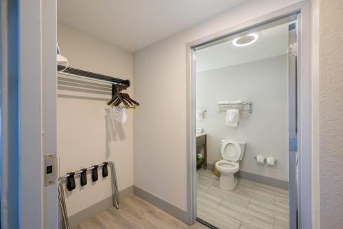 a bathroom with a toilet and a sliding glass door at Hawthorn Extended Stay by Wyndham Panama City Beach in Panama City Beach