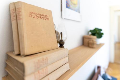 a stack of books sitting on a shelf in a room at Vila Heide in Česká Kamenice