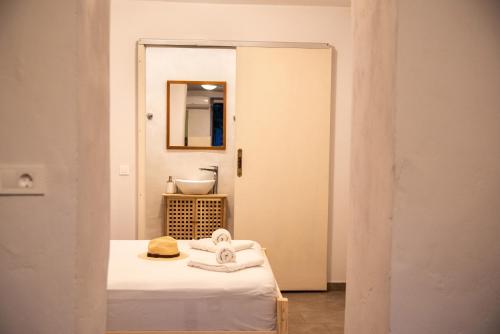 a room with a bed and a mirror and a sink at Feneri 3 -Cozy rustic Apt 20' from Elafonisi beach in Perivólia