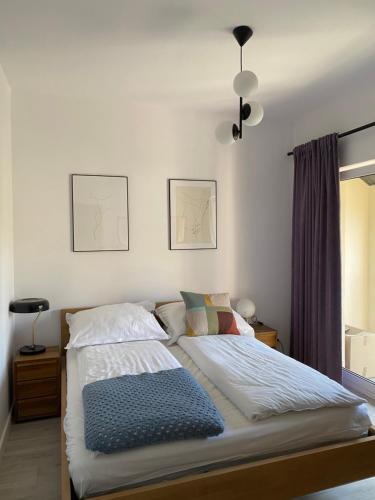 een slaapkamer met een bed met een blauwe deken bij Domek Pod Sosnami in Rozewie