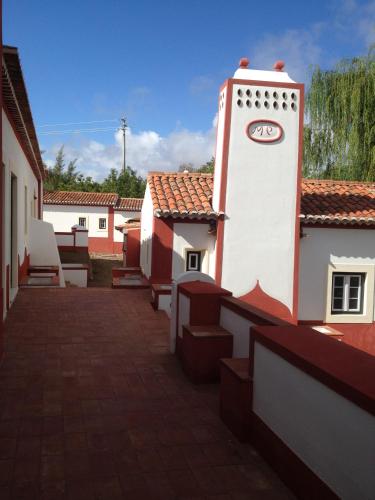 a building with a clock on the side of it at Hotel Rural Monte da Provença in Elvas