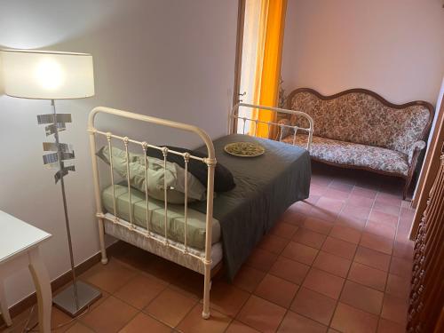 Habitación pequeña con cama y sofá en Le Mazet de choubouloute, en Saint-Gilles