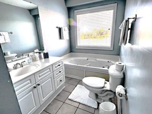 a bathroom with a tub and a toilet and a sink at 3 Story Lake House Near Historic Downtown in Charleston