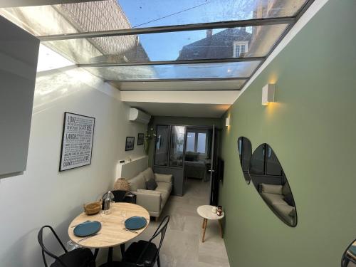 ein Wohnzimmer mit einem Dachfenster sowie einem Tisch und Stühlen in der Unterkunft Loft central climatisé avec verrière in Vernon