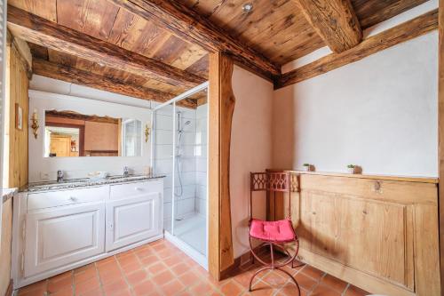 a bathroom with a shower and a pink chair at Chez Jade et Ambre in Eguisheim