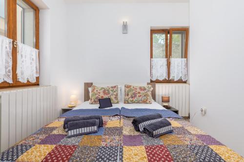 a bedroom with a large bed with a quilt on it at Apartment-Old Town-Dundo in Pula