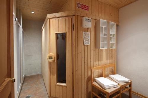 a wooden room with two chairs and a door at Garni Bellavista in Arabba