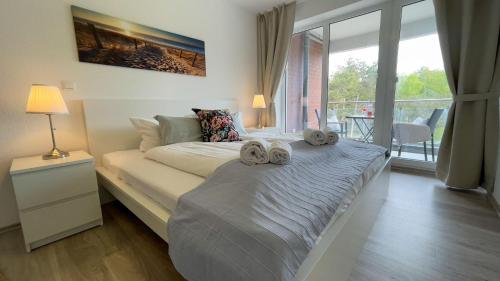 a bedroom with a bed with two towels on it at Strandhaus-Nordseebrandung-Fewo-B2-3 in Cuxhaven