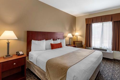 a hotel room with a large bed and two windows at Best Western Plus Boulder Louisville in Louisville