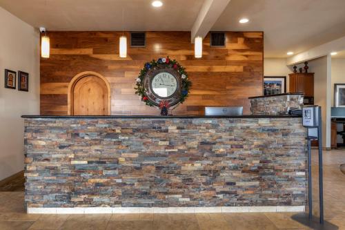 a counter with a clock on a brick wall at Best Western Swiss Clock Inn in Pecos
