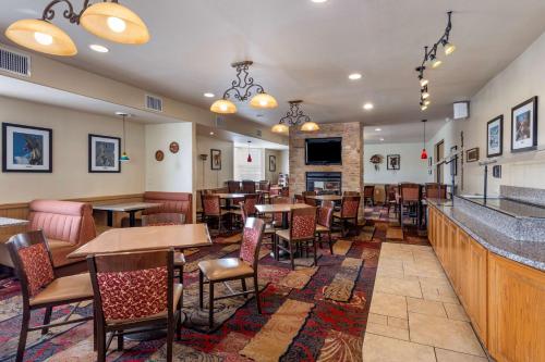 a restaurant with tables and chairs and a bar at Best Western Swiss Clock Inn in Pecos