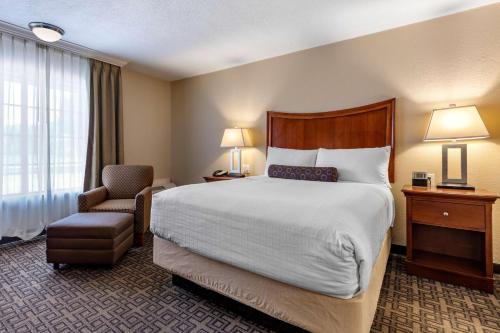a hotel room with a bed and a chair at Best Western Swiss Clock Inn in Pecos