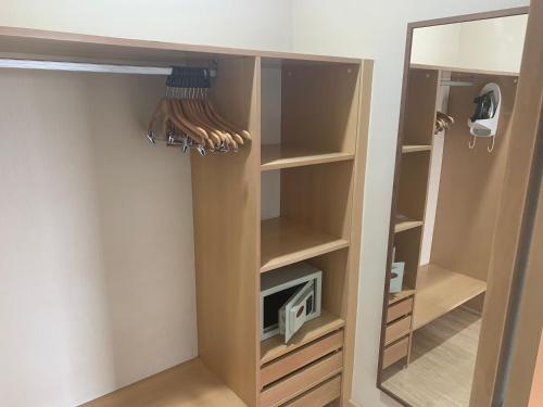 Lindo Flat na Barra da Tijuca com vista para o mar في ريو دي جانيرو: خزانة مع تلفزيون ومرآة في الغرفة