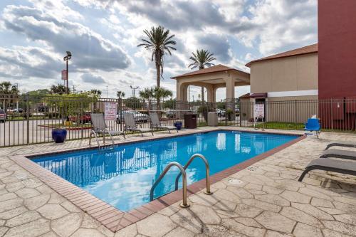 une grande piscine dans un complexe avec un bâtiment dans l'établissement Best Western Plus Orange County, à Vidor