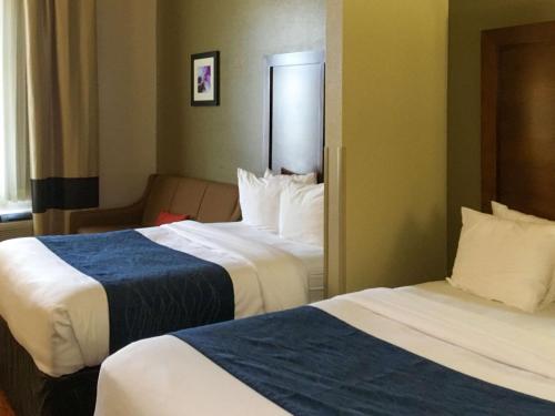 a hotel room with two beds and a couch at Comfort Inn & Suites near Kino Sports Complex in Tucson