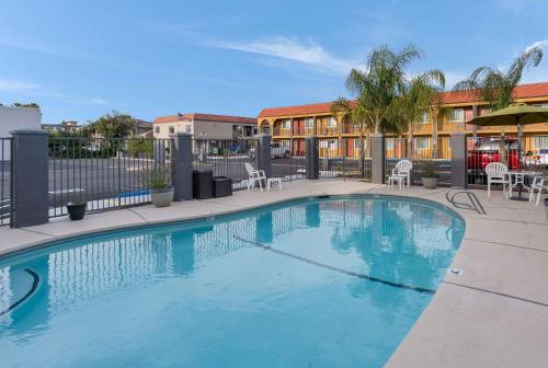 a swimming pool with chairs and tables and a building at Quality Inn Redding near I-5 in Redding