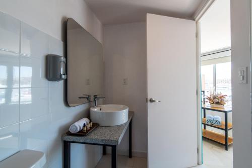 La salle de bains est pourvue d'un lavabo et d'un miroir. dans l'établissement Mayan Monkey Los Cabos, à Cabo San Lucas