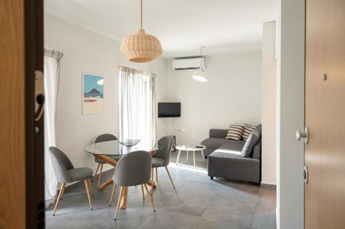 een woonkamer met een tafel en stoelen en een bank bij The H Experience Blackbird Spacious 2BD Apartment close to the beach in Xylokastron