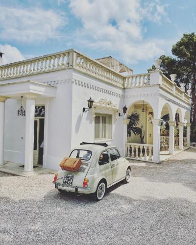 a small car parked in front of a white house at Masseria Principe di Puglia in San Vito dei Normanni