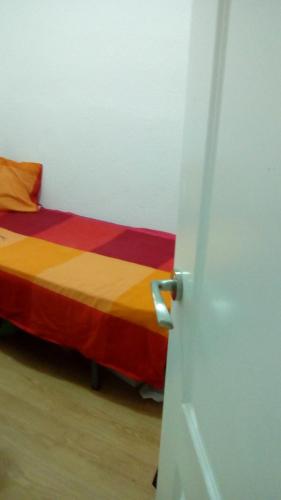Habitación con cama con manta colorida en Apartamento en Legazpi de 3 dormitorios pequeños en Madrid