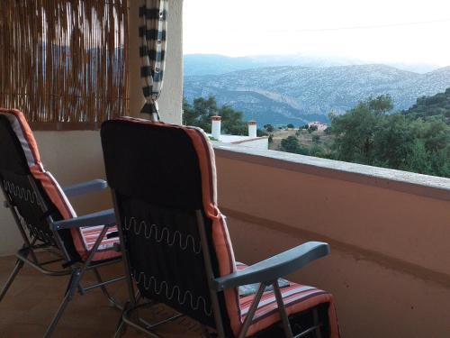 two chairs sitting on a balcony looking out at the mountains at Casa Lucia Campagna Relax in Dorgali