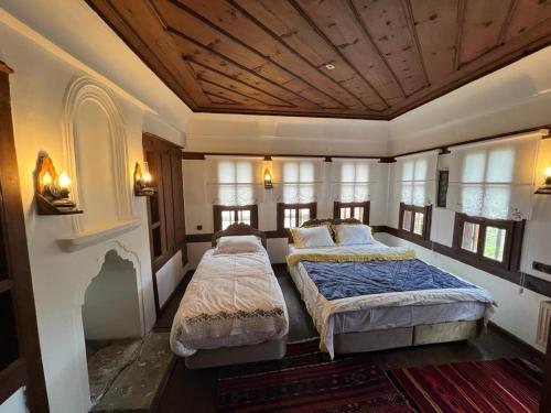 a bedroom with two beds in a room with windows at SARI KONAK Garden Otel Safranbolu in Safranbolu