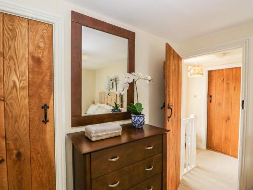 uma casa de banho com uma cómoda em madeira e um espelho em Mulberry Cottage em Grange Over Sands