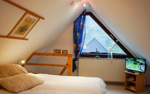 ein Schlafzimmer mit einem Bett und einem großen Fenster in der Unterkunft Am Flockengrund 26a/4 OG in Cuxhaven