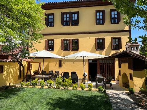 a building with tables and umbrellas in a yard at SARI KONAK Garden Otel Safranbolu in Safranbolu