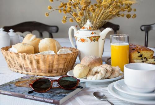 Hotel Solar dos Montes في سانتانا دوس مونتيس: طاولة عليها سلة خبز وكتاب ونظارات