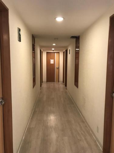 an empty hallway with a long hallway with wooden floors at Hotel Aeropuerto in Mexico City
