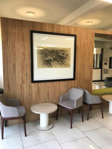 a waiting room with chairs and a picture on the wall at Hotel Aeropuerto in Mexico City