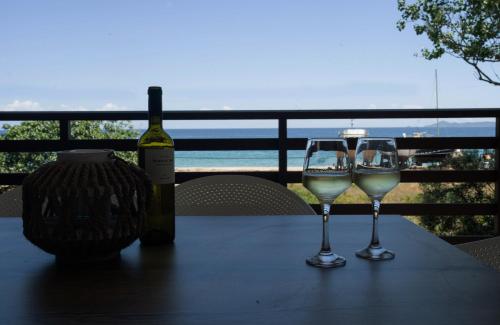 a bottle of wine and two wine glasses on a table at Marineiko Luxury Apartments in Ierissos