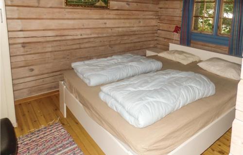 two beds in a room with wooden walls at Solbakken in Vikersund