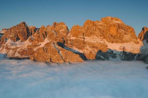 a view of a rocky mountain in the sky at Hotel Arcobaleno in Fai della Paganella