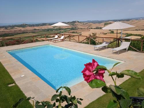 基昂尼的住宿－LA CASA DI CHIANNI La Pieve 2，游泳池旁设有两把椅子和一朵花