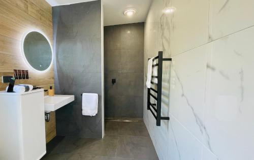 a bathroom with a sink and a mirror at Ohope Villas with Spa,Sauna,Pool, Adults Only in Ohope Beach
