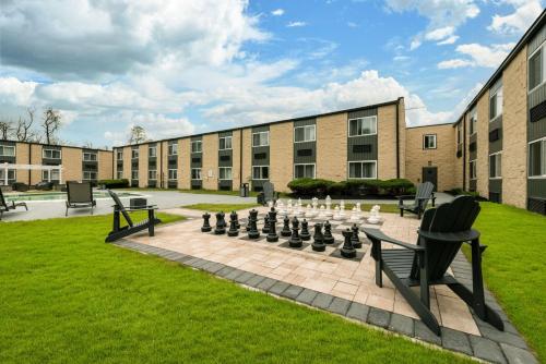 a courtyard with chairs and a chessboard in front of a building at SureStay Plus Hotel by Best Western McGuire AFB Jackson in Cookstown
