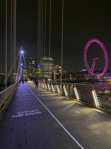 un puente de noche con el ojo de Londres en el fondo en Flat in Tower Bridge, en Londres