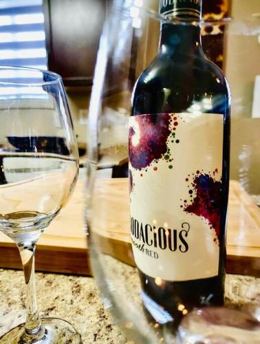 a bottle of wine sitting next to a glass at Spacious Basement suite in Camrose