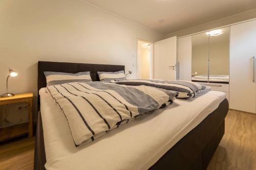 um quarto com uma cama grande e um espelho em Meeresblick-Morgensonne-Haus-3-WE-35 em Hohwacht