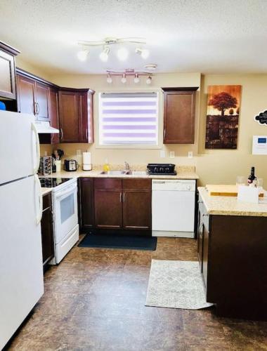 a kitchen with wooden cabinets and white appliances at Spacious Basement suite in Camrose