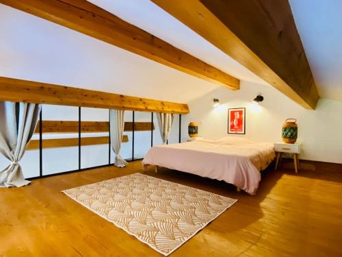 ein Schlafzimmer mit einem großen Bett und einem großen Fenster in der Unterkunft Le Loft Occitanie Sud de France in Ceilhes-et-Rocozels