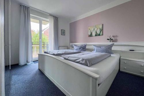 um quarto com 2 camas e uma janela em Ferienwohnung-47-mit-Schwimmbad-Sauna-Residenz-Passat-Doese em Cuxhaven