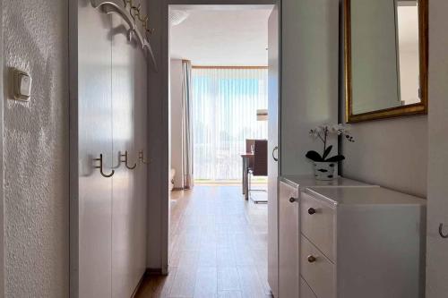 um corredor com um armário branco e um espelho em Ferienwohnung-47-mit-Schwimmbad-Sauna-Residenz-Passat-Doese em Cuxhaven