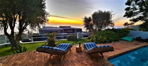 einen Hinterhof mit zwei Stühlen und einem Pool in der Unterkunft African Vibes Camps Bay in Kapstadt