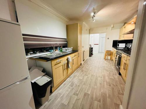 a large kitchen with wooden cabinets and a sink at U-DIN HOMES in Weymouth